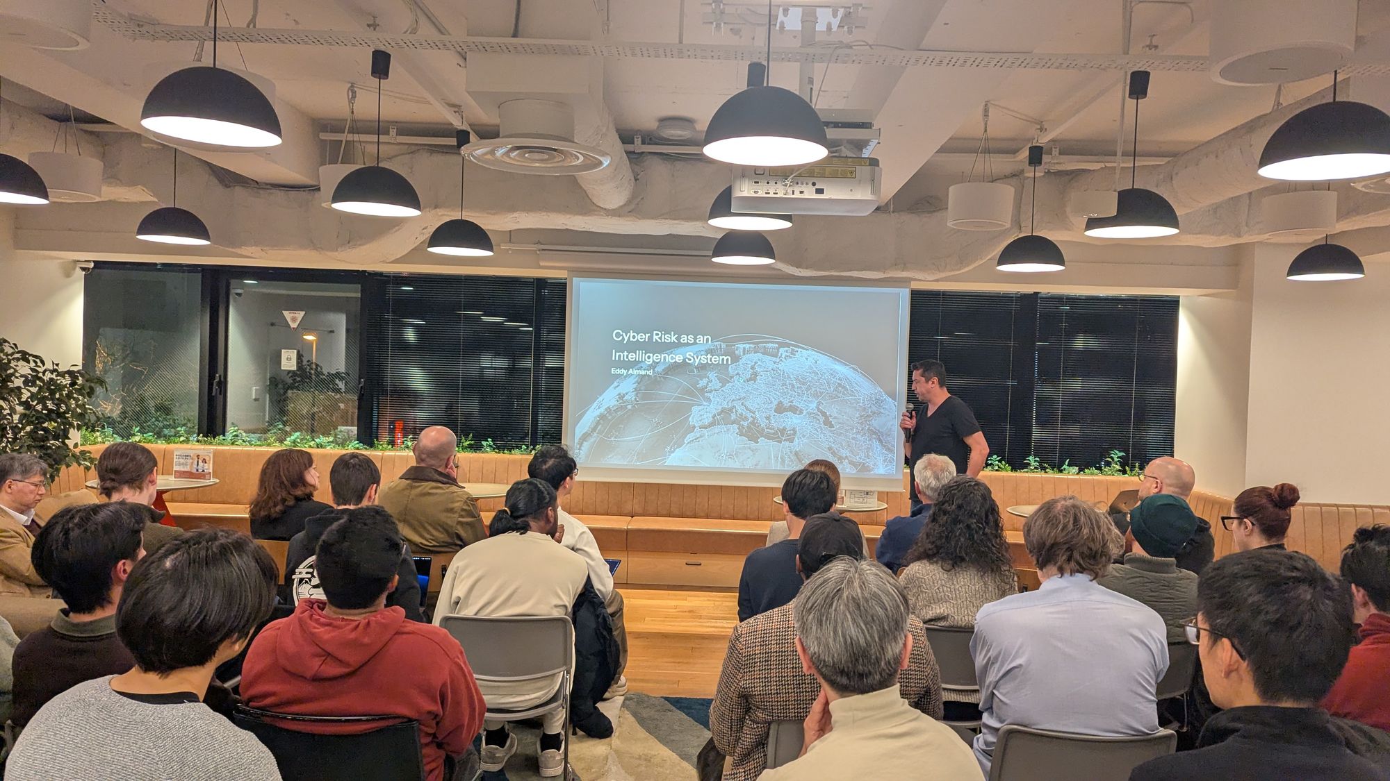 Speaker presentation and audience at AI x Risk & Security.