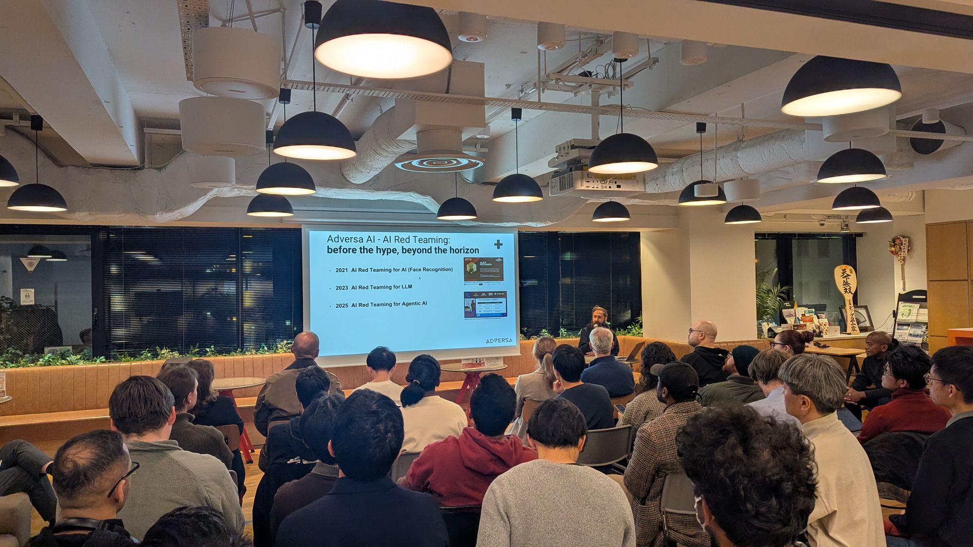Speaker presentation and audience at AI x Risk & Security.